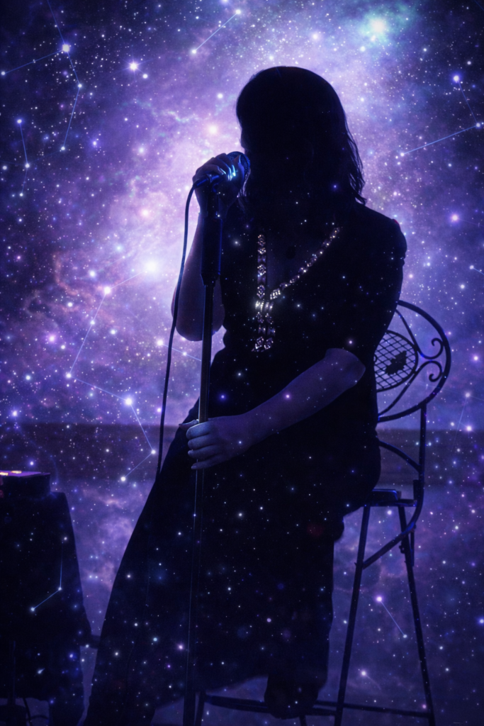 Juliette de Saint Rémy en concert, silhouette dans l'ombre sur fond de constellation